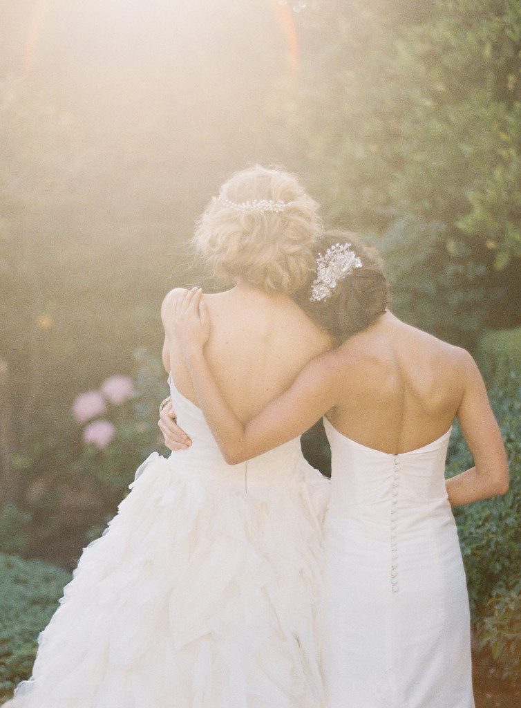 Bridesmaid with arm around bride