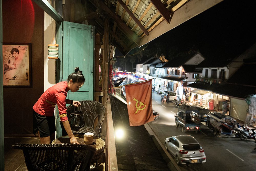 LAOS, NOVEMBER 2015. Luang Prabang, once considered a place for romantic dreamers, today is a magnet for expats in search of fortune in the new business of art and culture. A woman prepares a table at one of the many restaurants cropping up on the main promenade. Luang Prabang, Laos, 2015. @Giulio Di Sturco